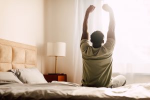 Ankylosing Spondylitis Linked to Morning Back Stiffness | Aaria Rheumatology Man stretching stiff back in the morning due to ankylosing spondylitis