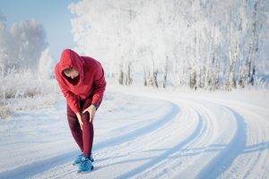Cold Weather Joint Pain | Aaria Rheumatology Traveller in cold weather holding her knee