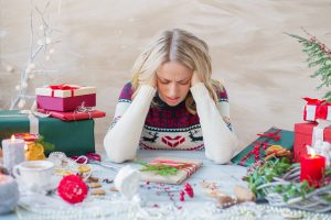 WomanInStressAboutChristmasHolidays | Aaria Rheumatology Holiday Stress & Autoimmune Flares – Why Your Body Reacts