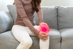 Woman on the sofa with knee joint pain