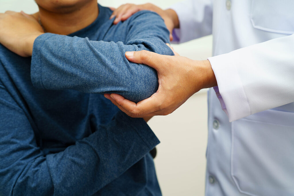 A doctor examining a patient’s elbow for inflammatory arthritis.